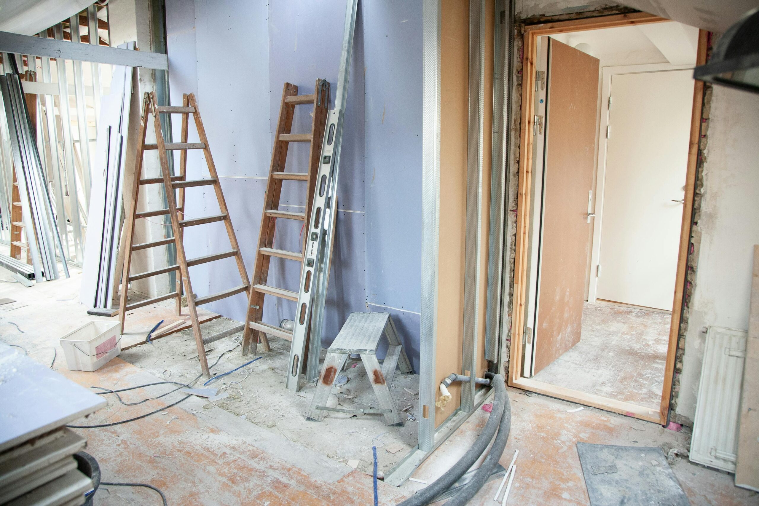 Construction site featuring ladders and tools in a home renovation setting.